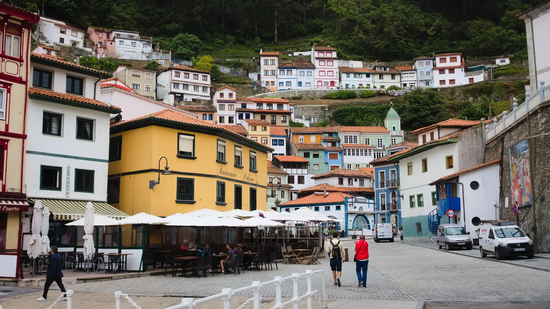 Una calle de Cudillero con las terrazas de los restaurantes y vecinos paseando