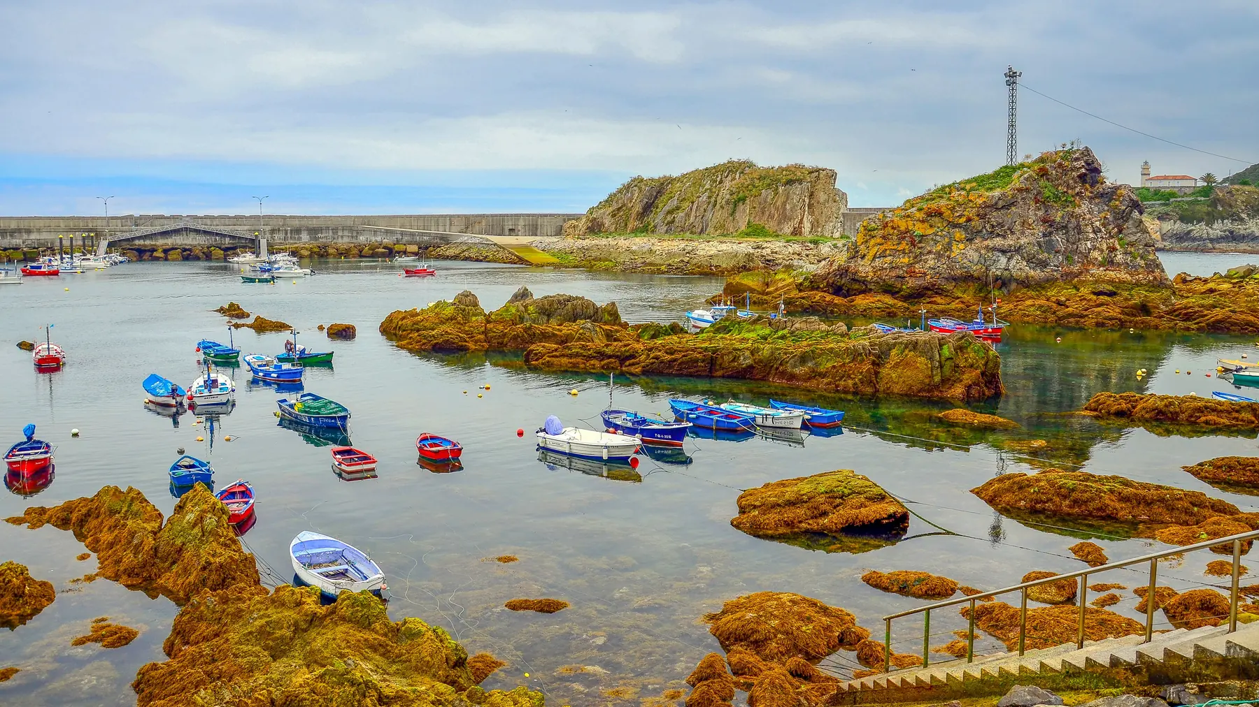 El puerto de Cudillero con las barcas de pesca entre las rocas